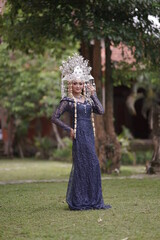 The model who is wearing suntiang traditional clothes from the city of padang, indonesia, looks very elegant and beautiful