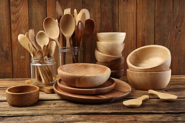 Many different wooden dishware and utensils on table