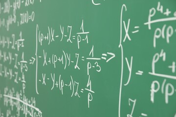 Many different math formulas written on chalkboard, closeup