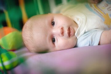Close-up detail portrait of cute little peaceful newborn baby boy child face with beautiful open eyes. Love and family emotion
