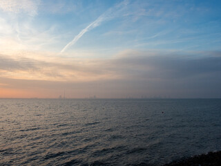Blick vom Friesenstrand in Tossens über den Jadebusen auf die Industrieanlagen in Wilhelmshafen bei Sonnenuntergang
