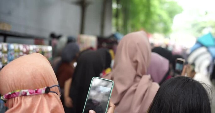 A carnival visitor uses a smartphone to capture the celebration of the arts and culture carnival in Cirebon, West Java, Indonesia.