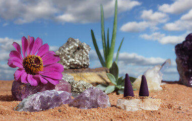 Fototapeta na wymiar Chakra Stones and Flowers on Australian Red Sand