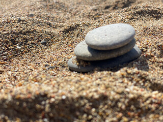 Fototapeta na wymiar Pyramid of flat stones on the sand