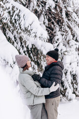 Fototapeta na wymiar Young couple in love hugging in the winter forest and having fun spending time together.Winter,Valentine's day,newlyweds, tenderness and love.