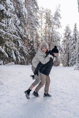 Young couple in love hugging in the winter forest and having fun spending time together.Winter,Valentine's day,newlyweds, tenderness and love.