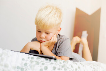 blondy boy spend your leisure time with tablet at home