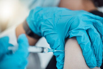 Vaccine, covid and healthcare with a doctor and patient in the hospital for an injection, treatment or cure. Hands, needle and syringe with a health professional injecting medicine into an arm