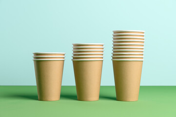 Stack of disposable eco friendly coffee cup on the pastel blue background. Biodegradable concept.