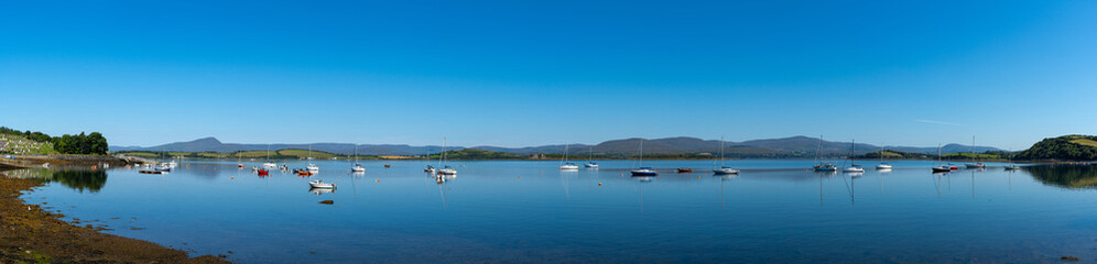 Fototapeta na wymiar panorama view of Bantry Bay in County Cork with many colorful sailboats anchored in the calm waters