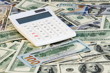Fototapeta premium A lot of money dollars with white calculator on desk. Exchange or saving concept. Paper banknotes