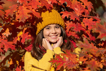 Naklejka na ściany i meble Teen child girl on autumn fall leaves background. cheerful teen kid in hat at fall leaves on natural background