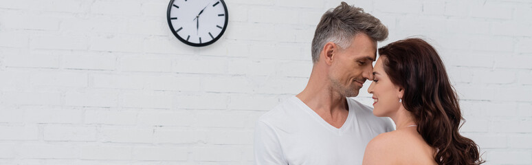 Side view of smiling couple standing with closed eyes at home, banner.