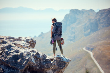Hiker, adventure and mountain top of a woman in rock climb, view and backpacking in nature. Active...
