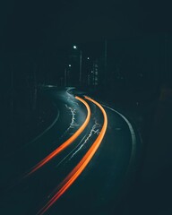 Vertical shot of orange light trails on a night road