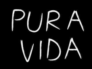 Pura vida text drawn with a brush in white on a black background