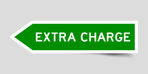 Green color arrow shape sticker label with word extra charge on gray background