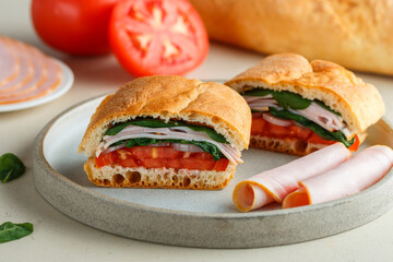 Baguette stuffed with tomatoes, onions, ham, spinach, basil. A multi-layered snack for gourmets. Healthy breakfast. Mediterranean cuisine. Selective focus