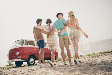 Photo of four people group fellows enjoy journey abroad hippie van wear casual outfit nature seaside beach outdoors