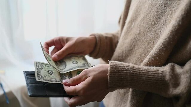 A woman's hand takes money out of her purse