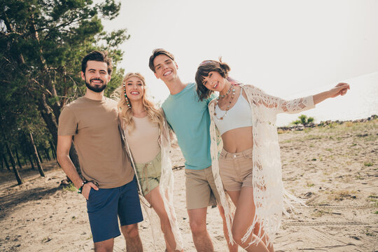 Photo of four carefree fellows embrace have dream weekend wear casual outfit nature seaside beach outside