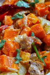 Pumpkin with meat and vegetables in a ceramic form on a wooden table