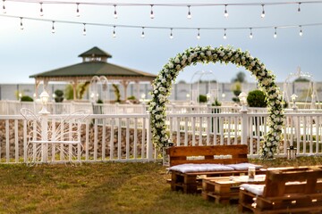View of an arch made of flowers at the wedding venue before the seascape in the evening