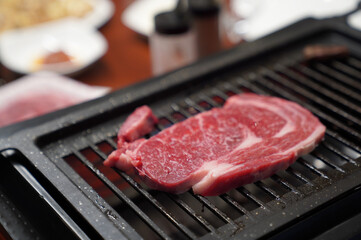 Food is prepared on the table and beef is grilled on the grill