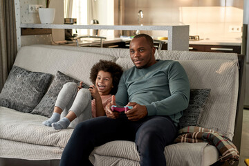 Excited son and focused father playing video game