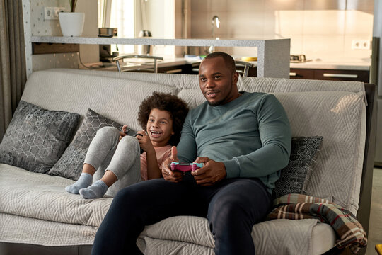 Excited son and focused father playing video game