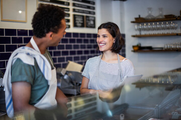 Grocery store coworkers talking while standing behind counter