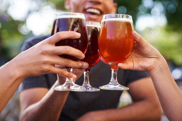 Mid-shot of three glasses of beer being raised in a toast