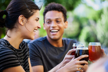 Young adult woman and friends toasting with beer