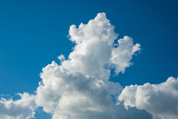 Dramatic puffy white clouds in the blue sky, summed day, no people.
