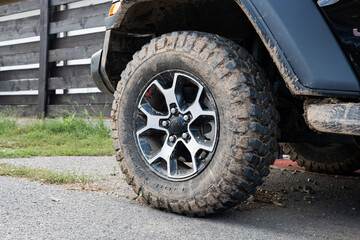Dried mud on SUV's off-road mud tires. Close up low angle view, no people