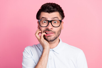 Closeup photo of young funny attractive handsome cute guy wear lenses bad vision nervous bite nails driving test problems isolated on bright pink color background