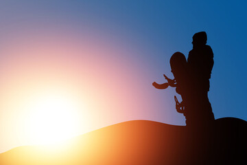 Snowboarders female silhouette with snowboard on sunset backdrop. Space for text. Snowboarding or...