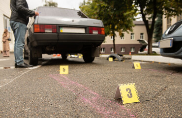 Scene of a traffic accident with car wreckage and police numbers indicating stopping distance and...