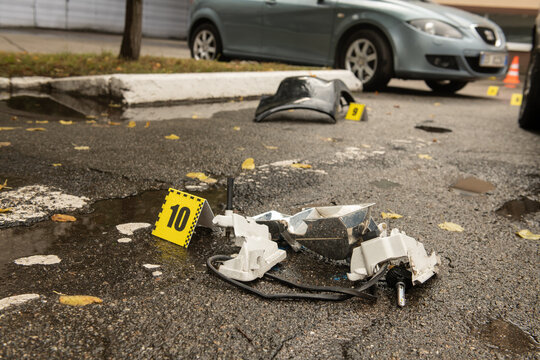 Scene of a traffic accident with car wreckage and police numbers indicating stopping distance and placement of objects, safety and traffic