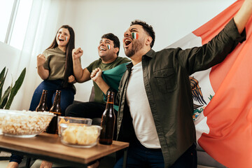 Fototapeta Football fans friends watching Mexico national team in live soccer match on TV at home obraz