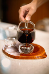 Barista making a Geisha coffee, pouring hot water from kettle over a ground coffee powder