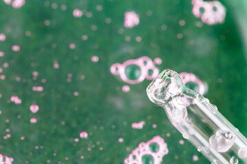 Pipette dropper on the background of liquid with bubbles