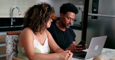 Couple concerned about money, black couple in front of computer at kitchen table