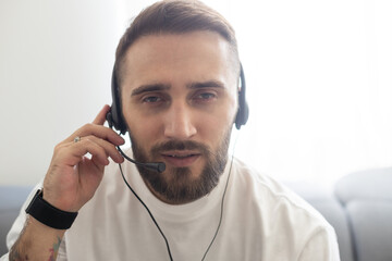 Head shot portrait man wearing glasses and headphones speaking at camera, making video call, using webcam, engaged in online conference at home, teacher mentor recording webinar, virtual event.