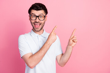 Portrait photo of young funny excited positive good guy wear white polo finger pointing empty space...