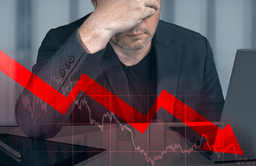 businessman holding hands on head looking at graph of declining profit. Businessman Looking Up At...