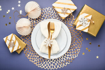Christmas festive table setting with white plates and gold cutlery. Flatlay, in blue and gold colors