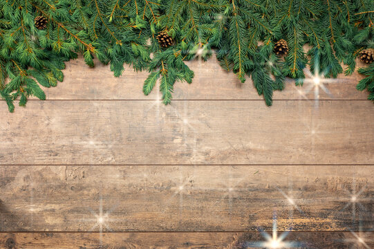 Christmas Background template. New Year background. Spruce branches on wooden table. Christmas concept. Frame made fir tree branches with stars on brown wooden table