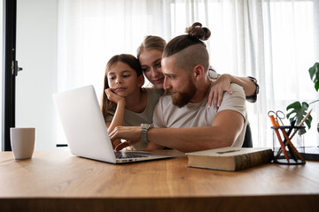Young family using laptop to shop online.