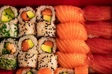 Sushi closeup, salmon and tuna nigiri, avocado maki, sesame, cucumber and chives
